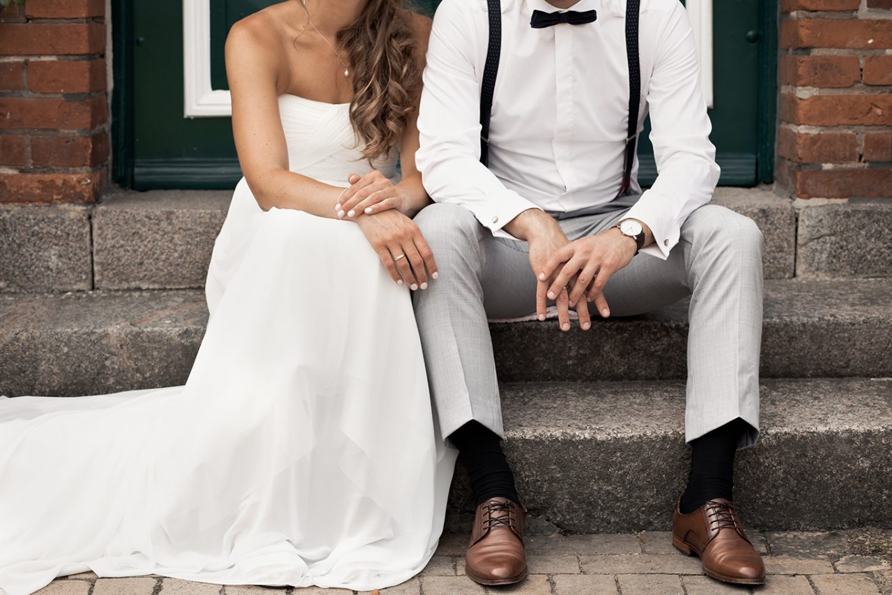 Brautpaar sitzt auf den Stufen eines Hauses. Hochzeitsfotografie